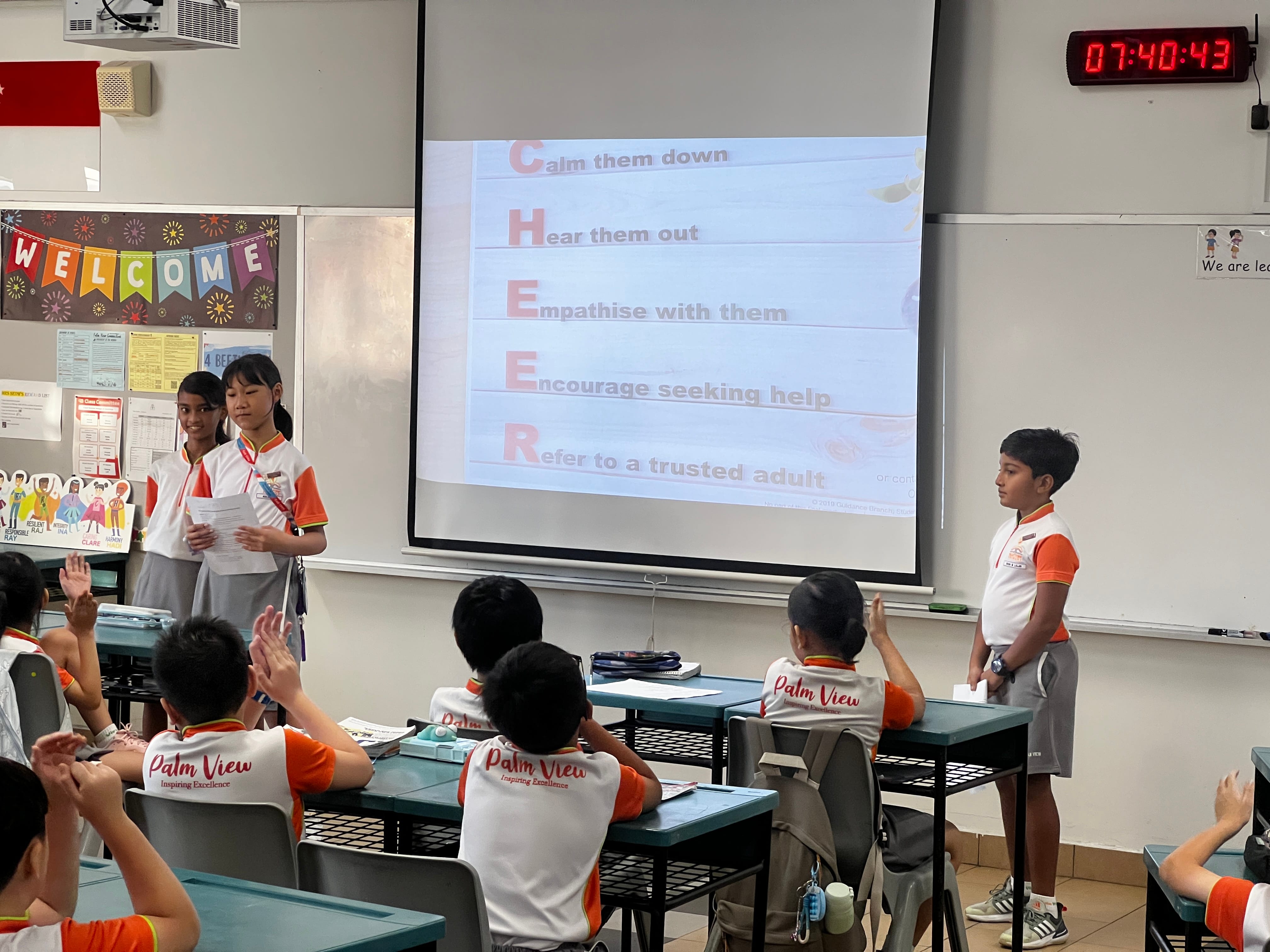 3 Peer Support Leaders standing in front of a class to do a presentation